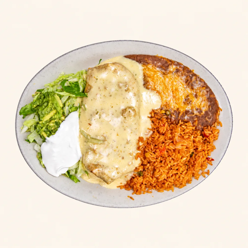 Classic Chimichanga topped with cheese sauce, with rice, refried beans, sour cream and guacamole