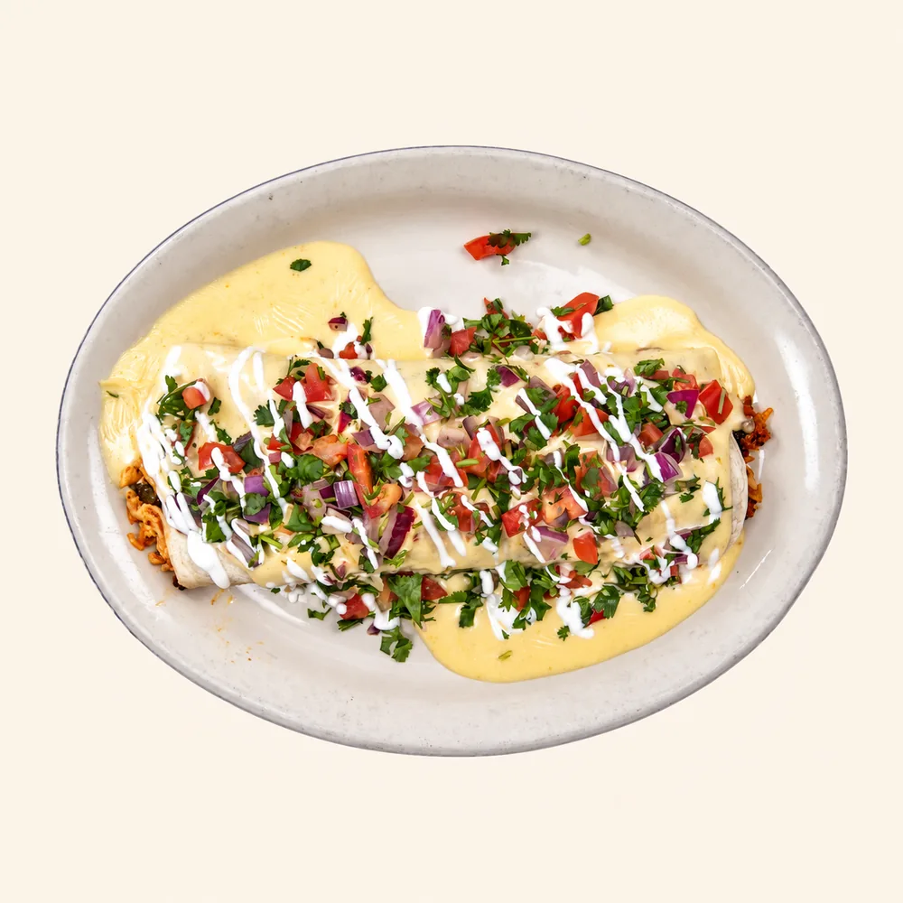 Chori Burrito covered in cheese sauce, sour cream and pico de gallo