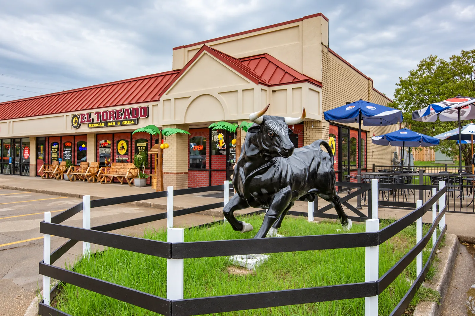 El Toreado Mexican Bar & Grill on EP True Parkway in West Des Moines, with a black bull statue on the front lawn and patio umbrellas